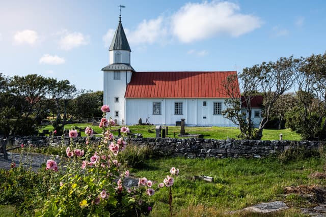 Käringöns hvite kirke med roser i forgrunnen